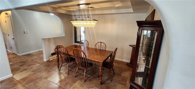 5312 Manuel Dr, Las Vegas, NV 89149 - dining space with baseboards, an inviting chandelier, a tray ceiling, and arched walkways