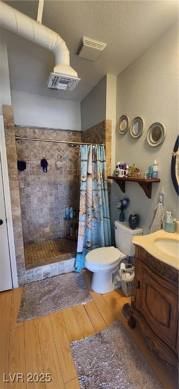 5312 Manuel Dr, Las Vegas, NV 89149 - bathroom featuring toilet, wood finished floors, vanity, visible vents, and a shower stall