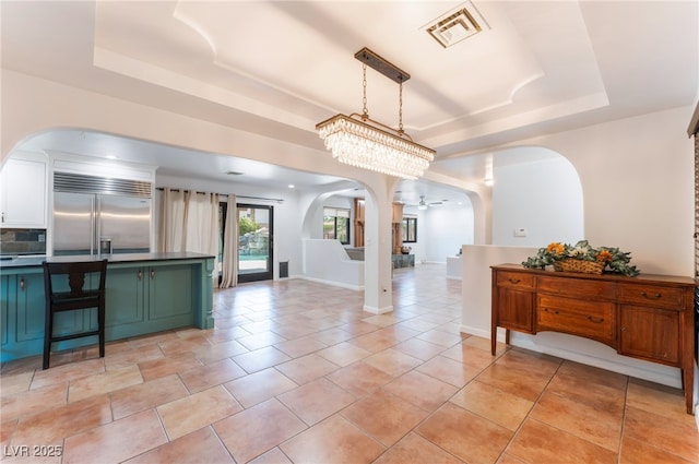 5312 Manuel Dr, Las Vegas, NV 89149 - kitchen with built in fridge, a raised ceiling, arched walkways, green cabinets, and dark countertops