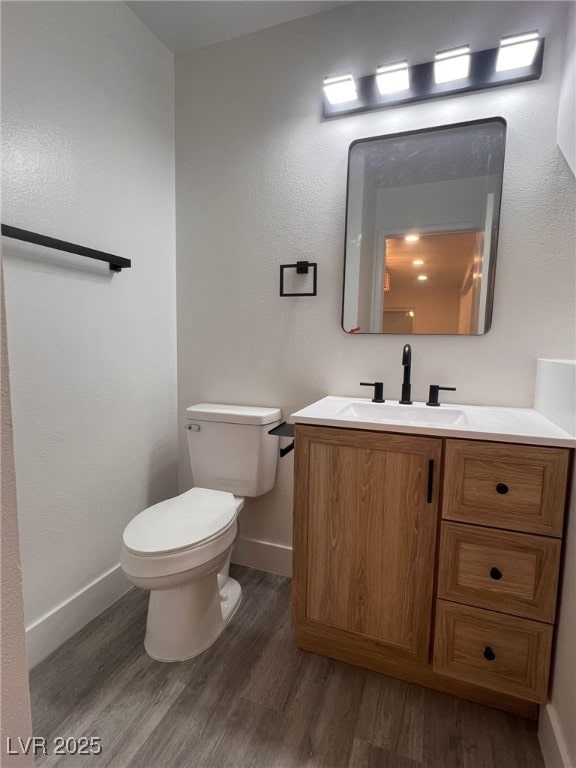 3686 Lincoln Rd, Las Vegas, NV 89115 - half bath featuring baseboards, wood finished floors, vanity, and toilet