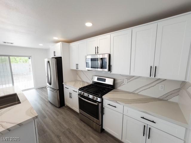 3686 Lincoln Rd, Las Vegas, NV 89115 - kitchen featuring wood finished floors, appliances with stainless steel finishes, white cabinetry, visible vents, and recessed lighting