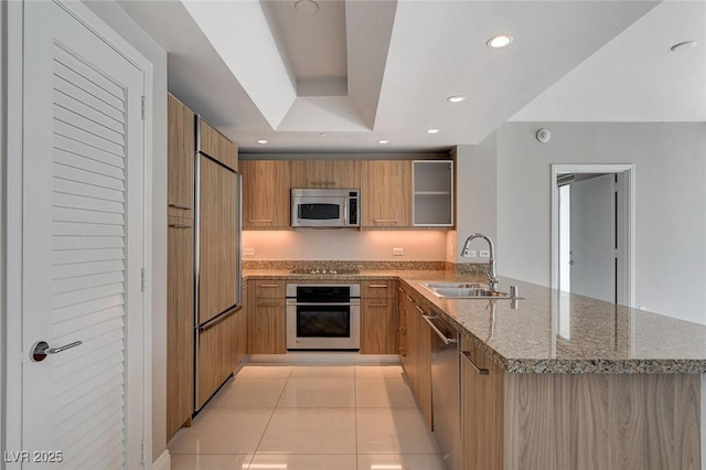 222 Karen Ave Unit 302, Las Vegas, NV 89109 - kitchen featuring light stone counters, a sink, stainless steel appliances, recessed lighting, and a peninsula