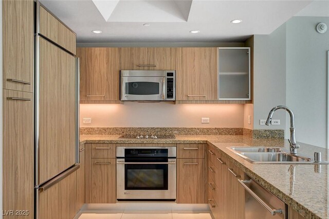 222 Karen Ave Unit 302, Las Vegas, NV 89109 - kitchen featuring recessed lighting, light stone counters, stainless steel appliances, a sink, and modern cabinets