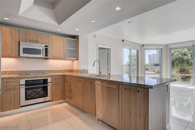 222 Karen Ave Unit 302, Las Vegas, NV 89109 - kitchen featuring dark stone counters, a sink, appliances with stainless steel finishes, recessed lighting, and a peninsula