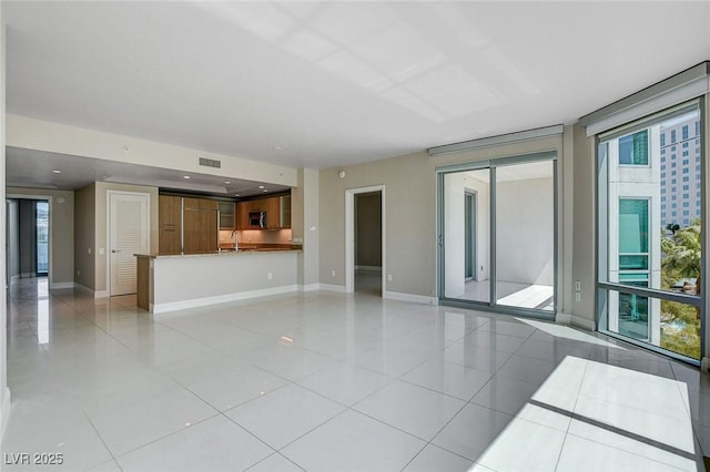 222 Karen Ave Unit 302, Las Vegas, NV 89109 - unfurnished living room featuring light tile patterned floors, a sink, and baseboards