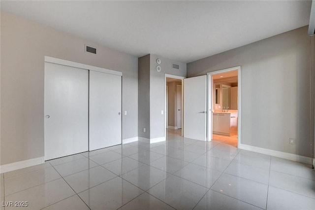 222 Karen Ave Unit 302, Las Vegas, NV 89109 - unfurnished bedroom featuring baseboards, visible vents, light tile patterned flooring, and a closet