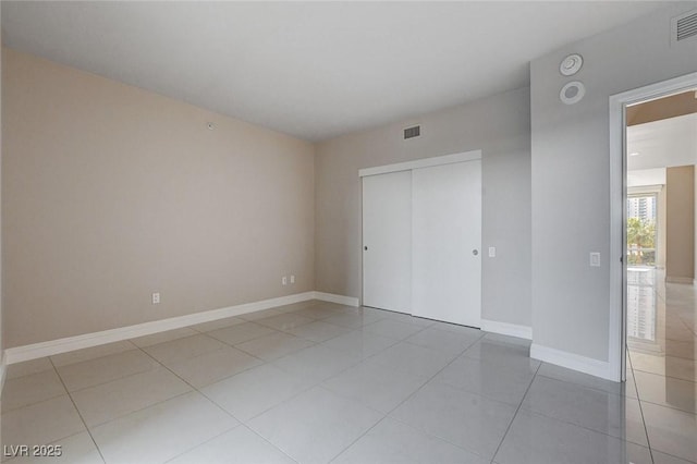 222 Karen Ave Unit 302, Las Vegas, NV 89109 - unfurnished bedroom featuring baseboards, visible vents, light tile patterned floors, and a closet