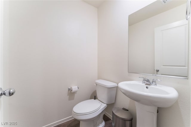 bathroom featuring baseboards, toilet, and wood finished floors