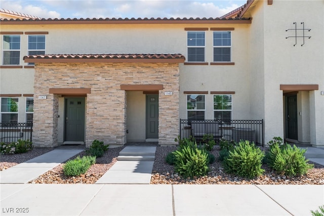 townhome / multi-family property featuring stone siding and stucco siding