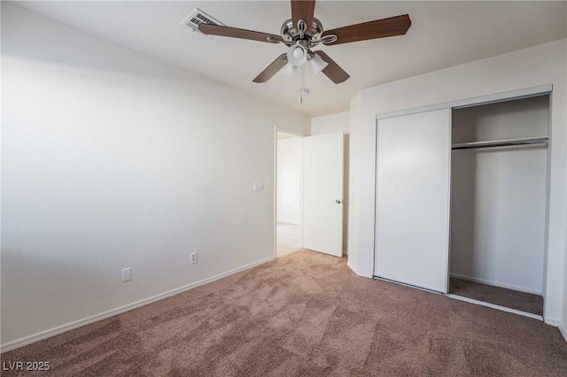 unfurnished bedroom featuring a closet, baseboards, carpet floors, visible vents, and ceiling fan