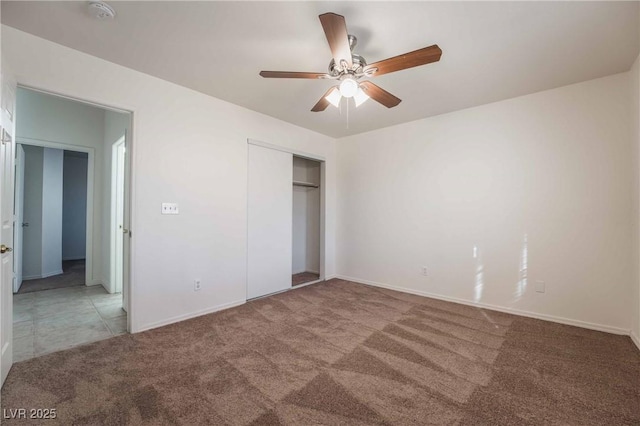unfurnished bedroom featuring a closet, baseboards, ceiling fan, and carpet