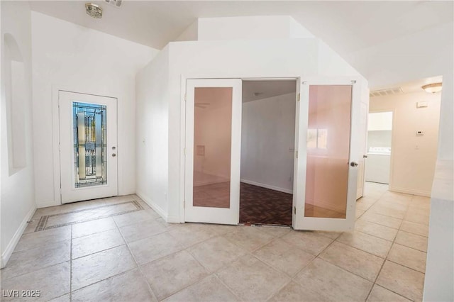 interior space featuring washer / clothes dryer, light tile patterned floors, baseboards, and visible vents