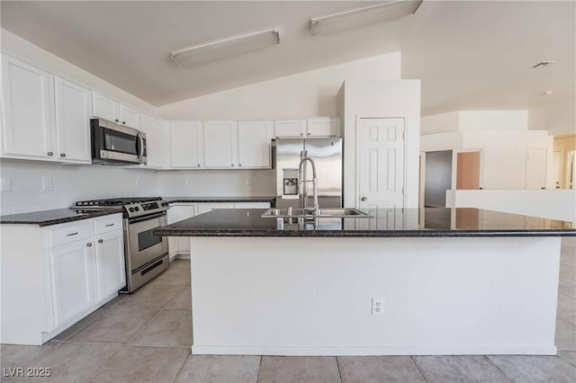 kitchen featuring lofted ceiling, white cabinetry, a sink, and appliances with stainless steel finishes