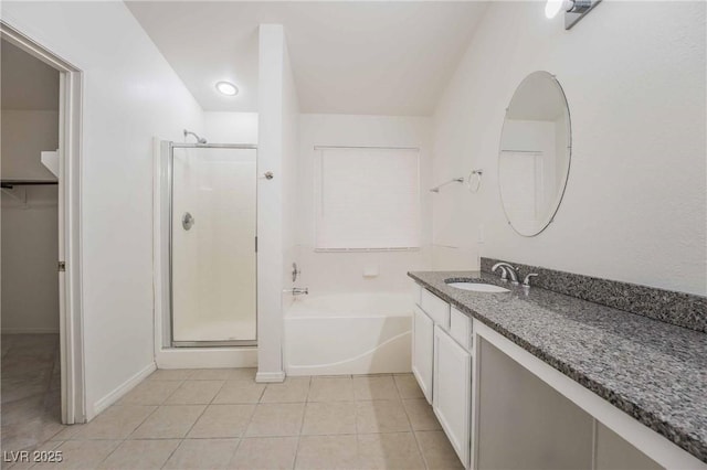 bathroom with a shower stall, tile patterned floors, a garden tub, and vanity