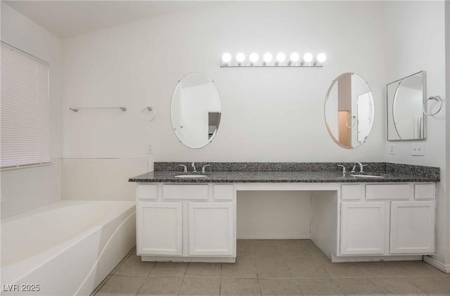 full bath featuring a garden tub, double vanity, a sink, and tile patterned flooring