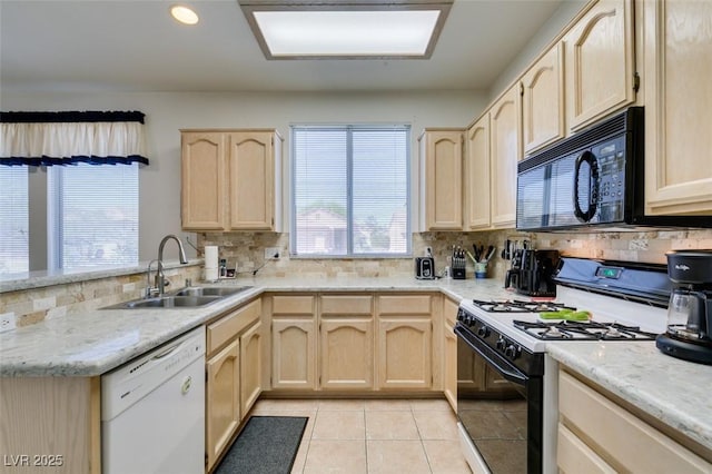 kitchen with black microwave, light brown cabinetry, a sink, white dishwasher, and gas range oven