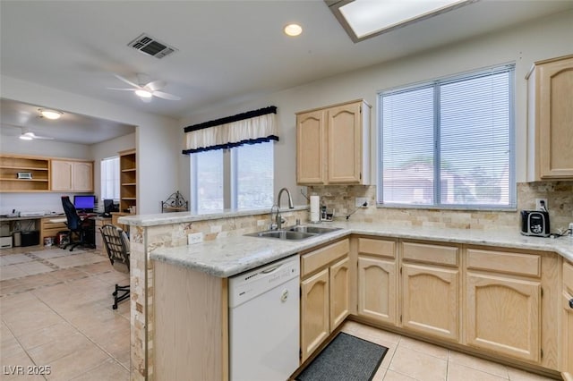 kitchen featuring a sink, a peninsula, dishwasher, and light brown cabinets