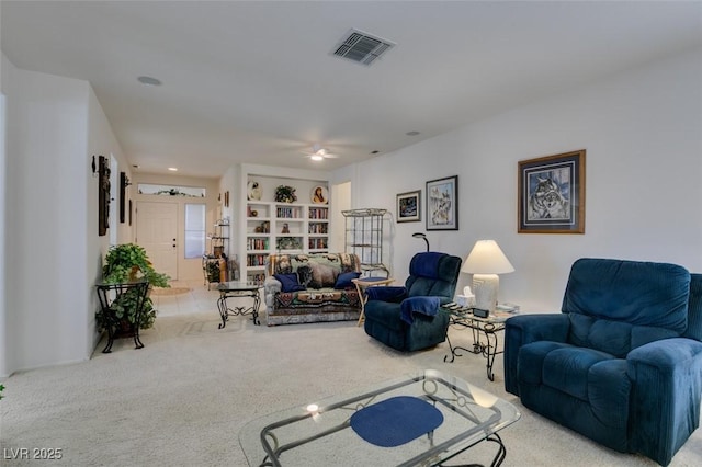 carpeted living area featuring visible vents and ceiling fan