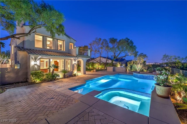 11573 Glowing Sunset Ln, Las Vegas, NV 89135 - pool at twilight featuring a fenced backyard, a pool with connected hot tub, and a patio