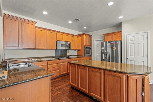 2244 Manosque Ln, Henderson, NV 89044 - kitchen featuring dark wood-style floors, a center island, visible vents, appliances with stainless steel finishes, and a sink