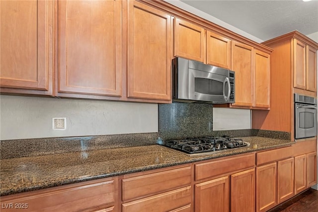 2244 Manosque Ln, Henderson, NV 89044 - kitchen with dark stone countertops, wall oven, dark wood-style floors, stainless steel microwave, and gas cooktop