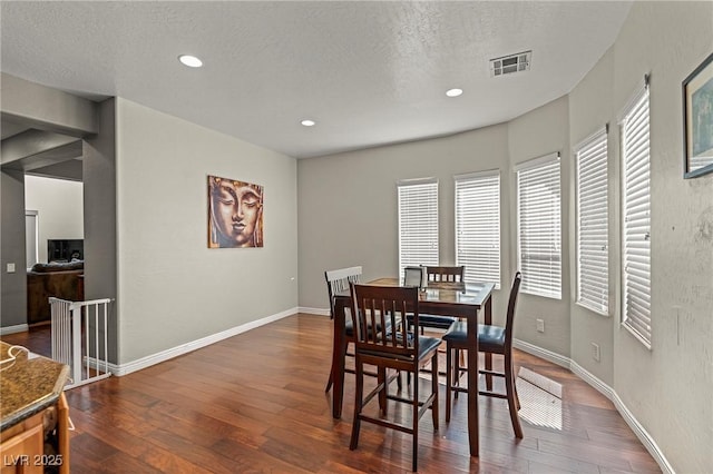 2244 Manosque Ln, Henderson, NV 89044 - dining space featuring baseboards, recessed lighting, a textured ceiling, dark wood-type flooring, and visible vents