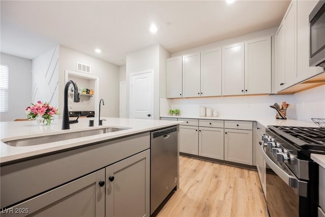 3525 Serravalle Ln, Henderson, NV 89044 - kitchen featuring stainless steel appliances, a sink, light wood-style flooring, light countertops, and recessed lighting