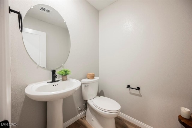 3525 Serravalle Ln, Henderson, NV 89044 - half bathroom featuring wood finished floors, toilet, and baseboards