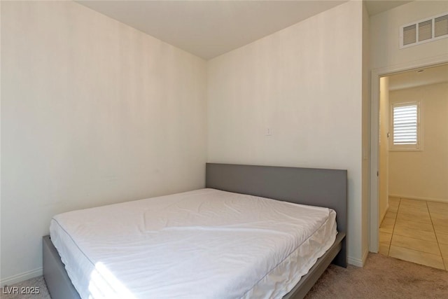 carpeted bedroom featuring visible vents and baseboards