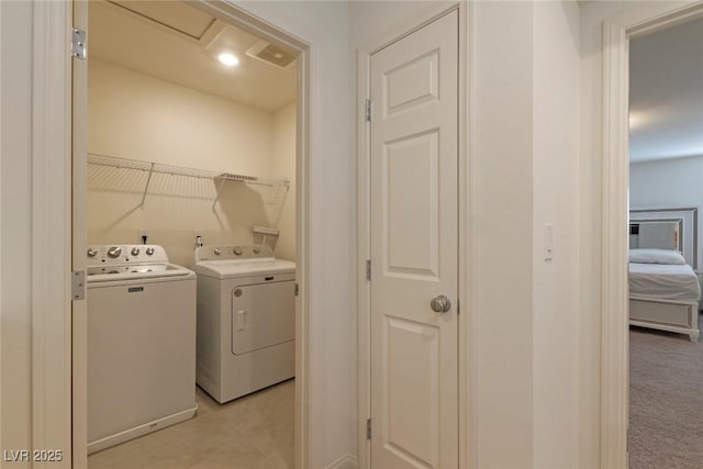clothes washing area featuring separate washer and dryer and laundry area