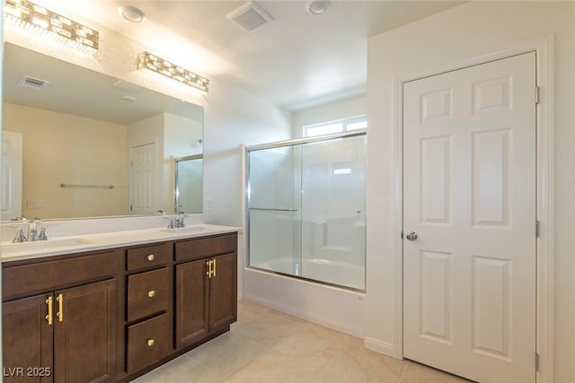 full bath with a sink, visible vents, double vanity, and tile patterned flooring