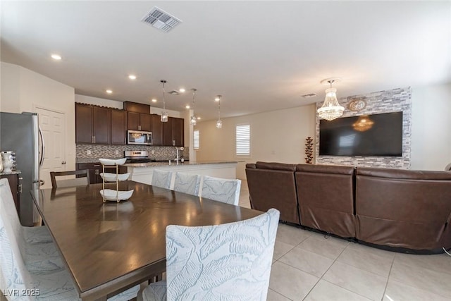 dining area with a chandelier, light tile patterned floors, visible vents, and recessed lighting