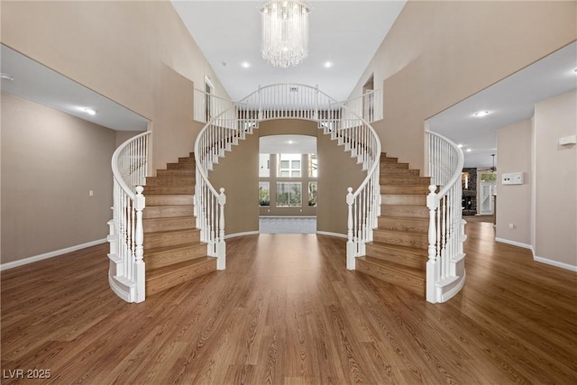 7460 Grassy Field Ct, Las Vegas, NV 89131 - foyer featuring stairway, wood finished floors, a chandelier, a towering ceiling, and baseboards