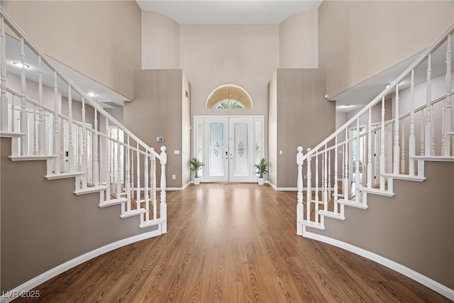 7460 Grassy Field Ct, Las Vegas, NV 89131 - entryway featuring a towering ceiling, stairway, baseboards, wood finished floors, and french doors