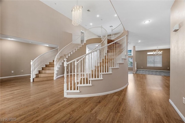 7460 Grassy Field Ct, Las Vegas, NV 89131 - staircase featuring a chandelier, wood finished floors, and baseboards