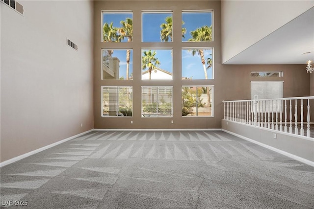 7460 Grassy Field Ct, Las Vegas, NV 89131 - spare room with a towering ceiling, carpet floors, baseboards, healthy amount of natural light, and a chandelier