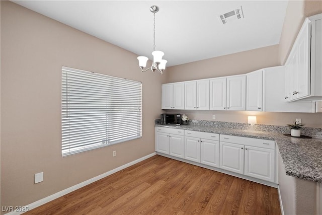 7460 Grassy Field Ct, Las Vegas, NV 89131 - kitchen with a chandelier, white cabinetry, light wood-style floors, baseboards, and hanging light fixtures
