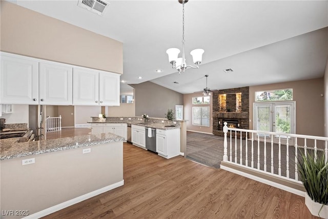 7460 Grassy Field Ct, Las Vegas, NV 89131 - kitchen with a peninsula, light wood-type flooring, a ceiling fan, dishwasher, and a large fireplace