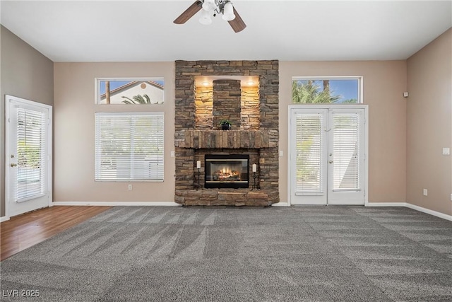 7460 Grassy Field Ct, Las Vegas, NV 89131 - unfurnished living room featuring a ceiling fan, a stone fireplace, baseboards, and carpet flooring
