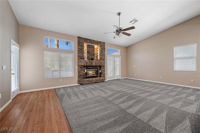 7460 Grassy Field Ct, Las Vegas, NV 89131 - unfurnished living room featuring plenty of natural light, ceiling fan, baseboards, a stone fireplace, and vaulted ceiling
