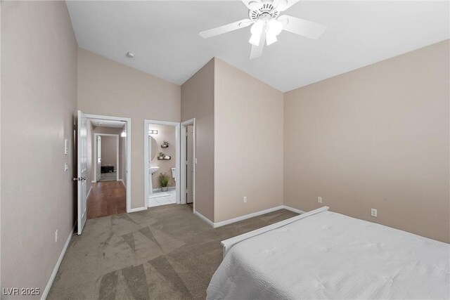 7460 Grassy Field Ct, Las Vegas, NV 89131 - carpeted bedroom featuring lofted ceiling, ensuite bath, baseboards, and ceiling fan