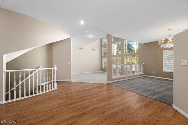 7460 Grassy Field Ct, Las Vegas, NV 89131 - unfurnished room featuring a chandelier, baseboards, wood finished floors, and lofted ceiling