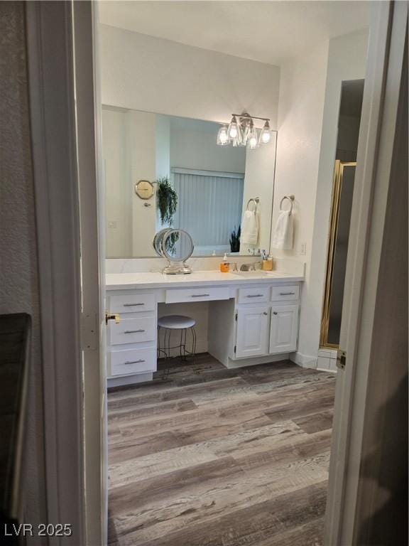 bathroom featuring vanity, a stall shower, and wood finished floors