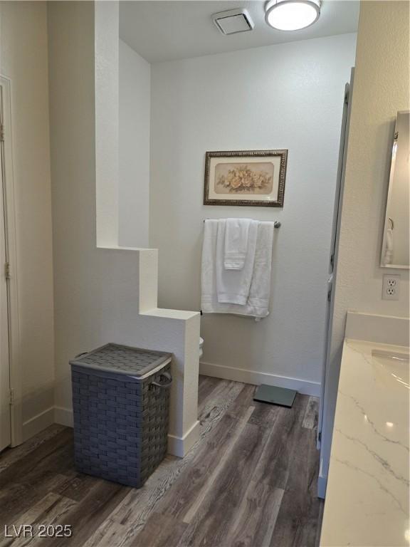 bathroom featuring wood finished floors, baseboards, and visible vents