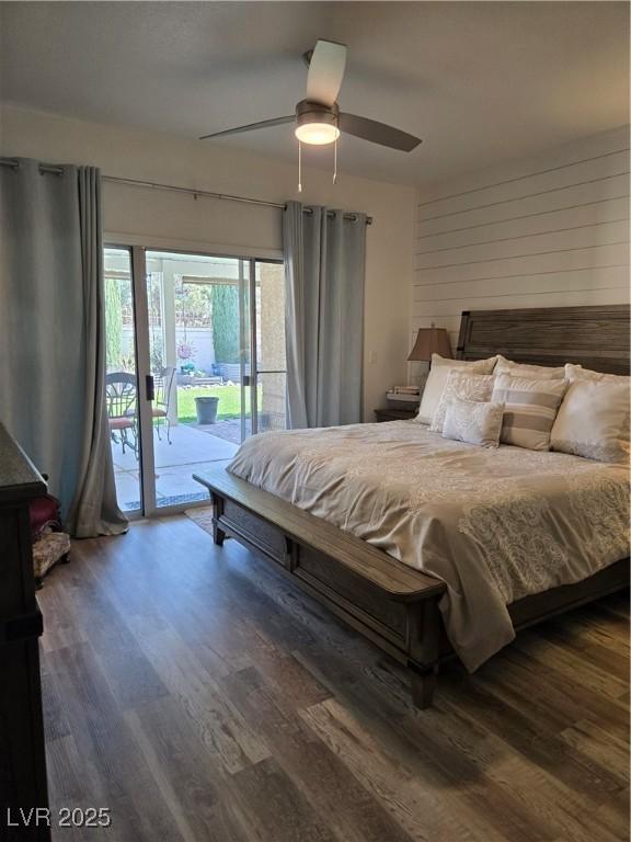bedroom featuring wood walls, access to exterior, a ceiling fan, and wood finished floors