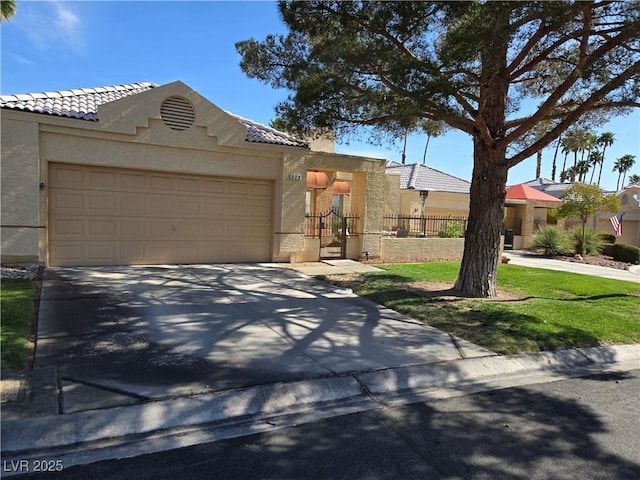 view of front of home with a tiled roof, fence, driveway, and stucco siding