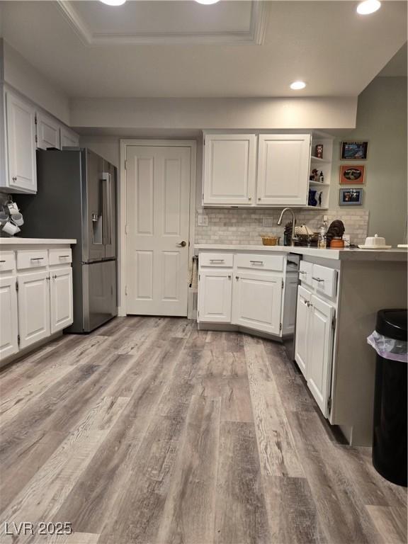 kitchen with light countertops, white cabinets, light wood finished floors, and recessed lighting