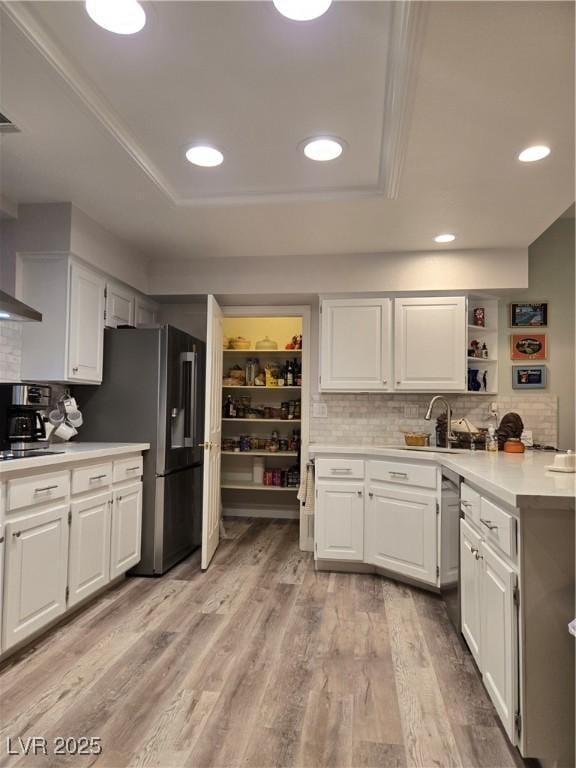 kitchen featuring tasteful backsplash, a sink, light countertops, and white cabinetry