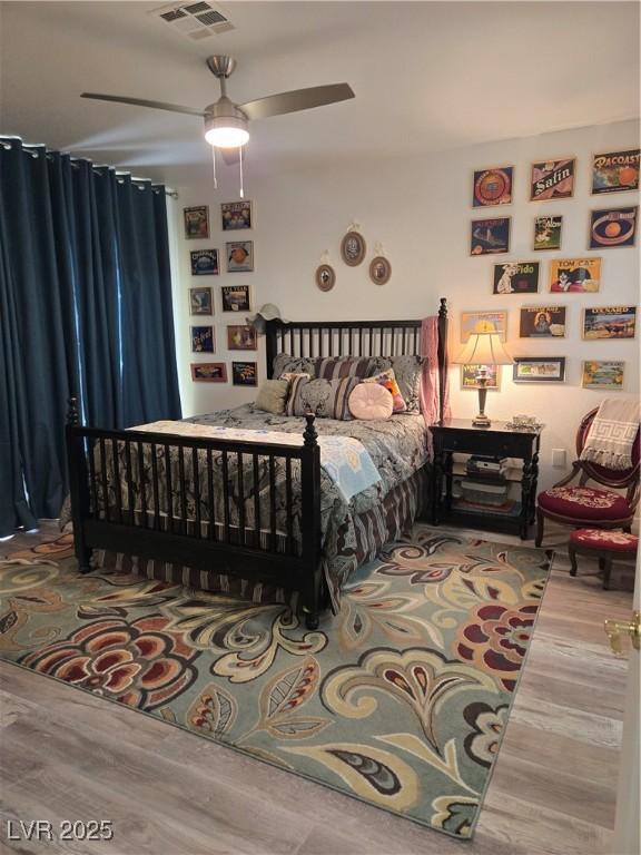bedroom featuring visible vents, a ceiling fan, and wood finished floors