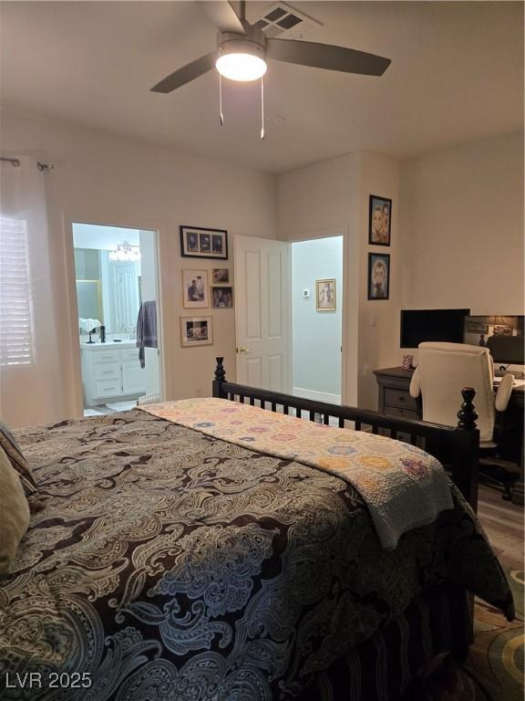 bedroom with wood finished floors, ceiling fan, visible vents, and connected bathroom